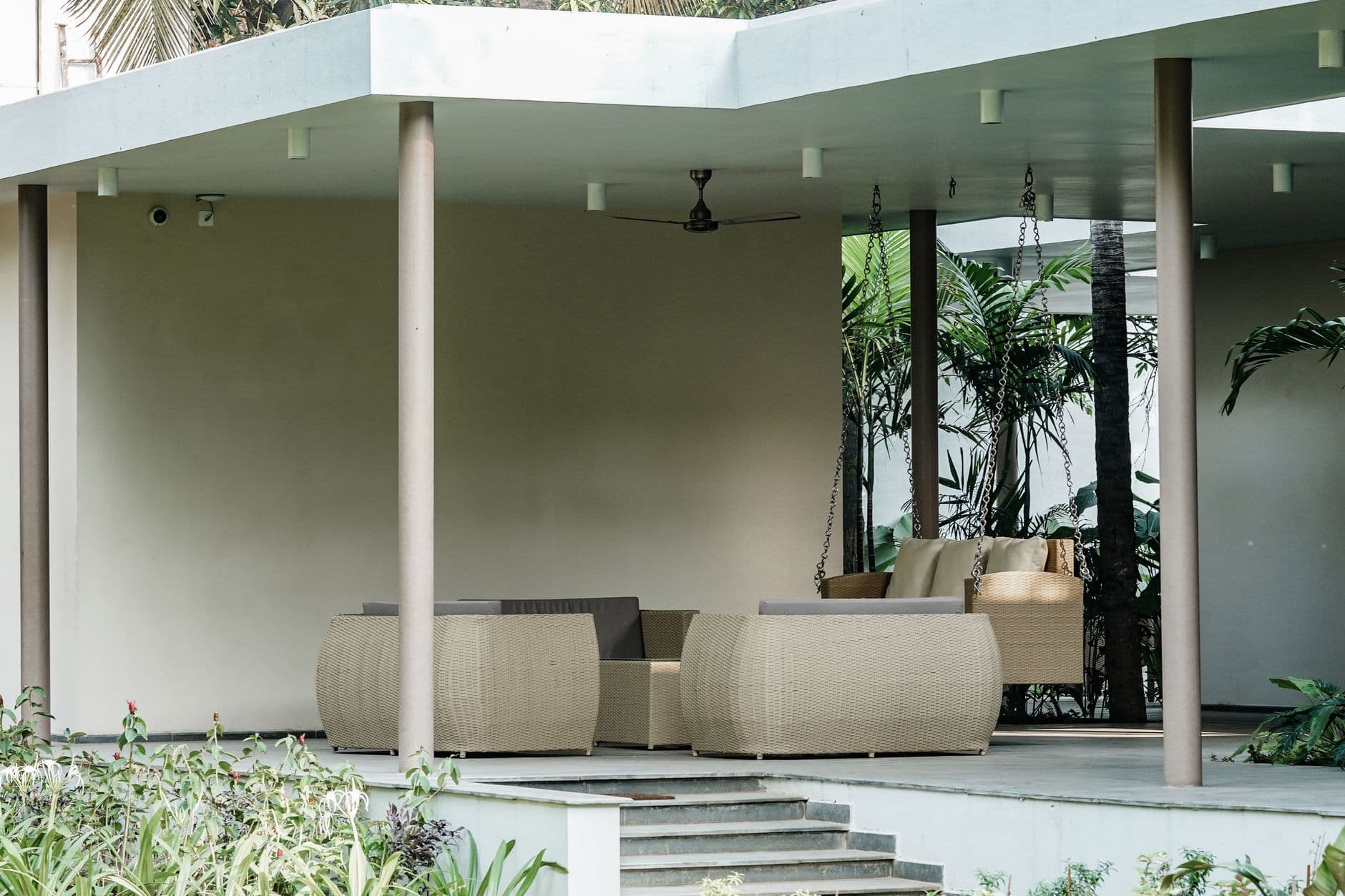 A covered outdoor patio with modern wicker seating
