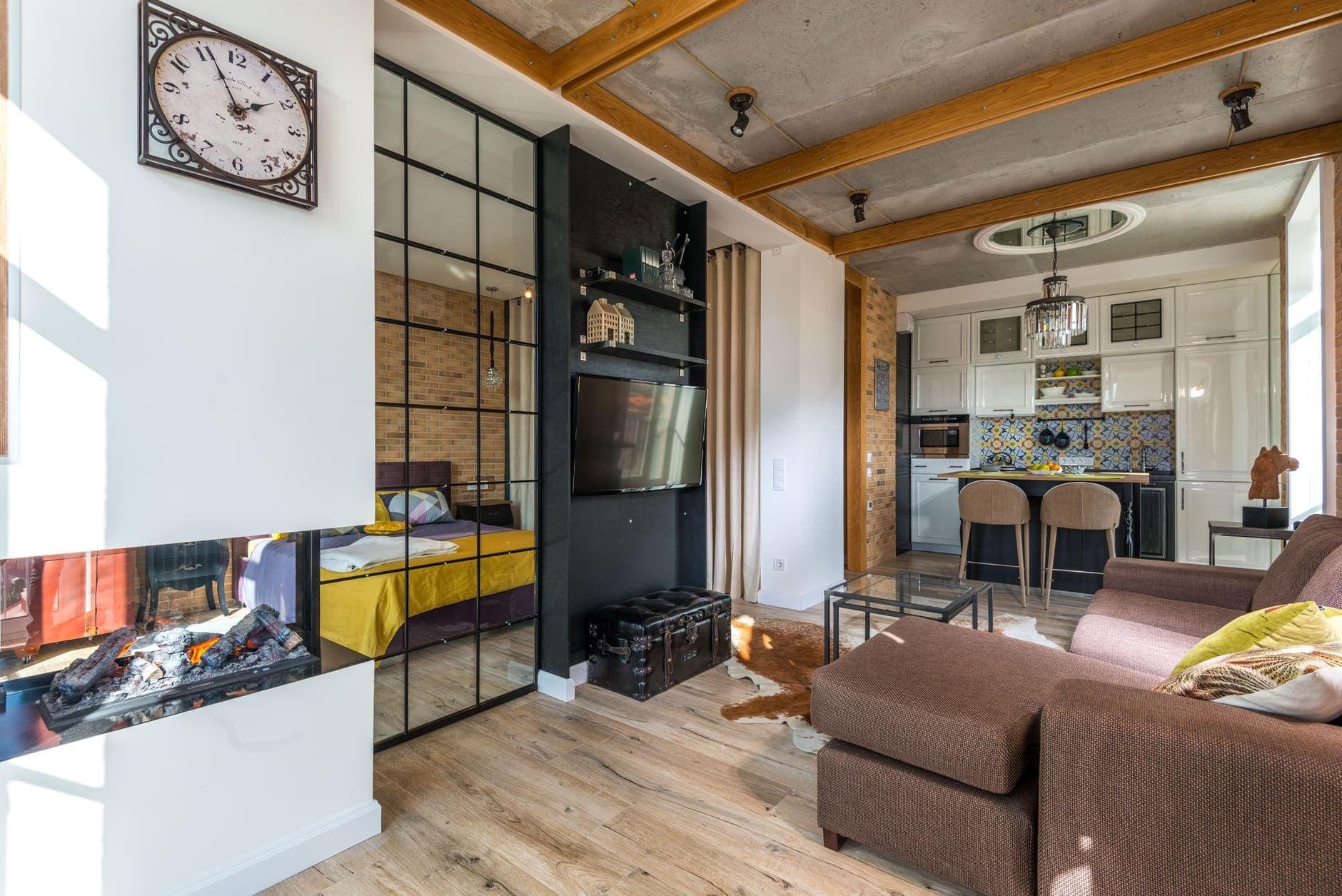A linear fireplace set into a dividing wall in an open-plan apartment