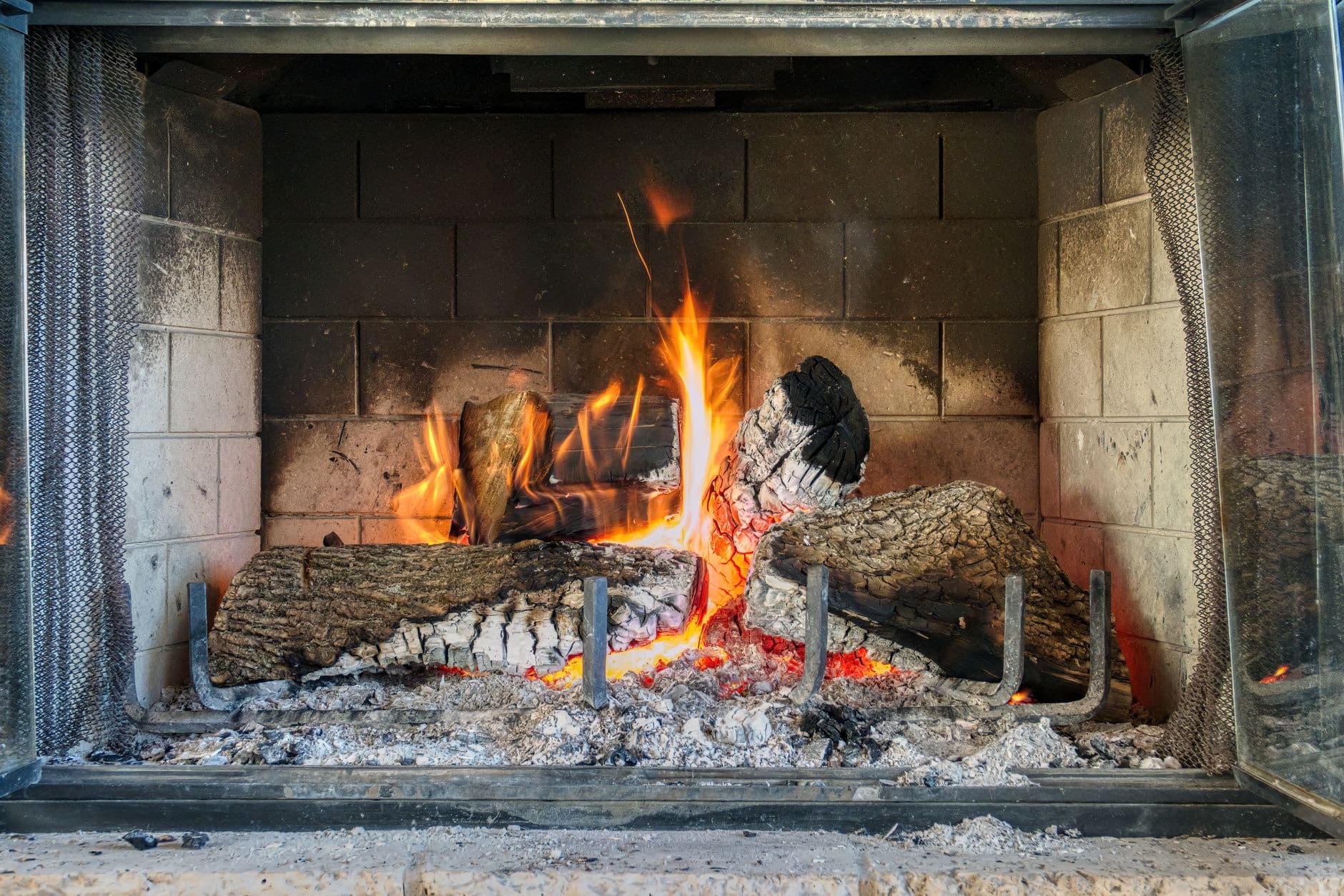 A close-up of a fire burning in a traditional indoor fireplace