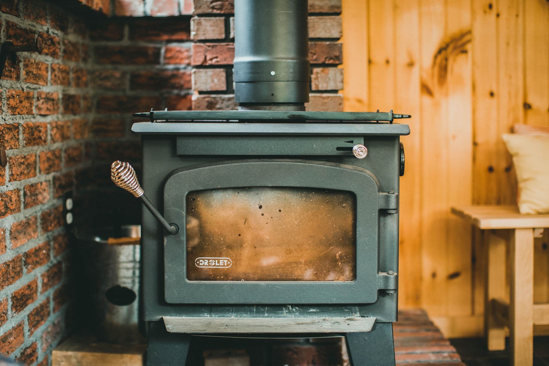 A freestanding stove burning in the corner of a room