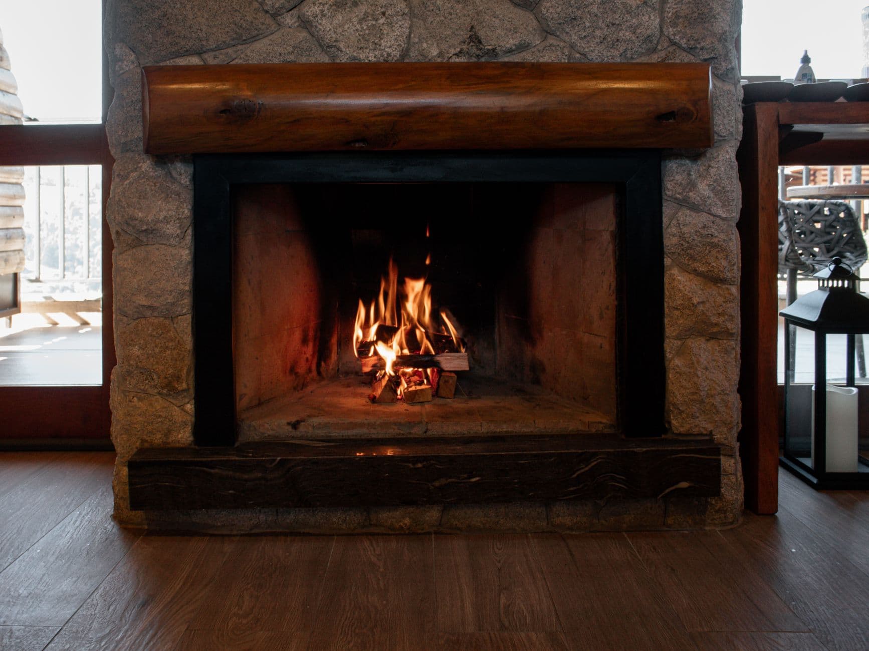 A wood fire burning in a stone masonry fireplace