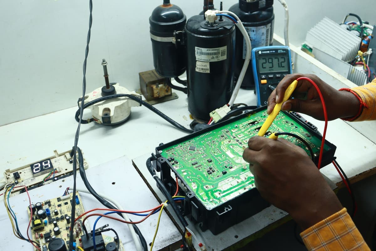 Hands using tools to repair an appliance