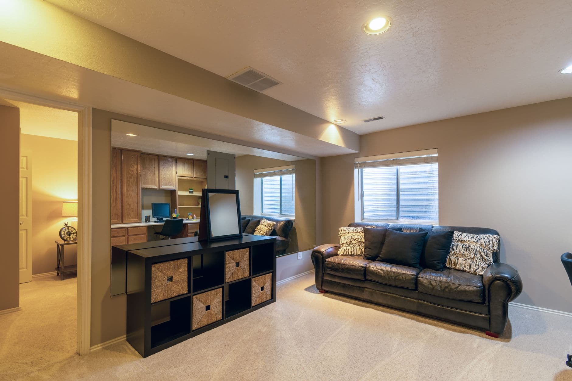 A basement living room with a leather sofa and modern decor