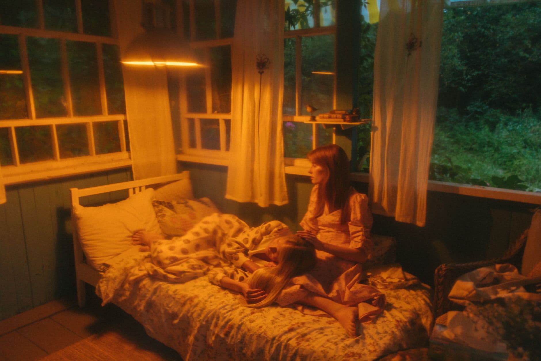 A warmly lit countryside bedroom in the evening