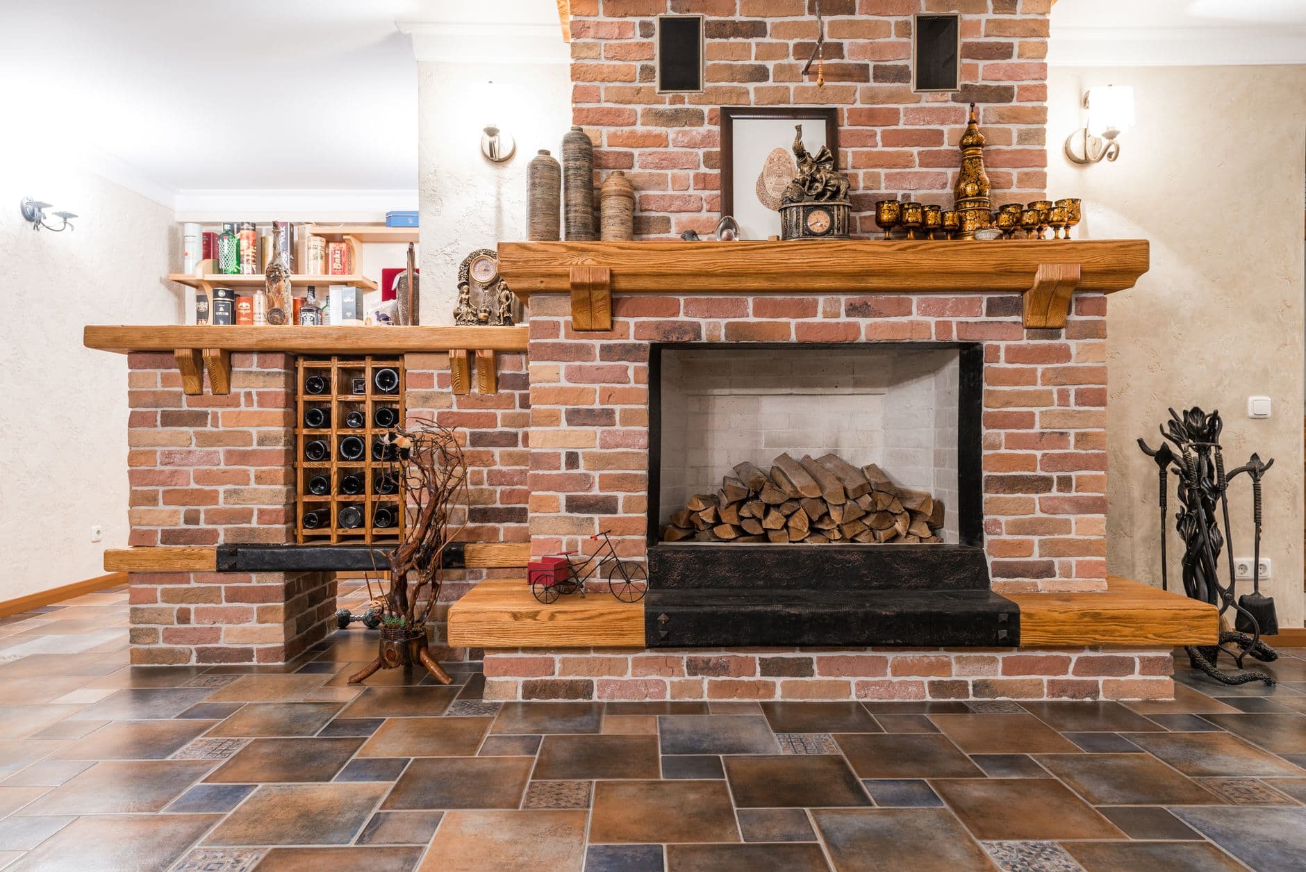 A brick fireplace opening with firewood stacked beside it