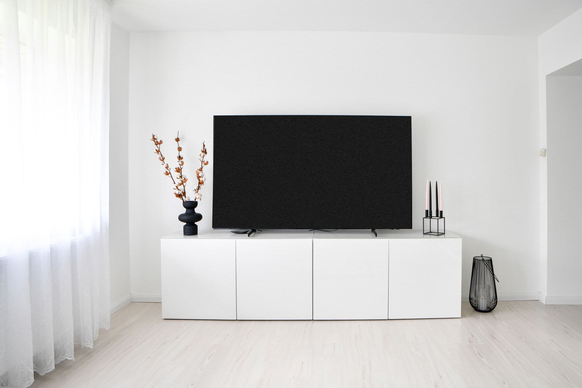 A minimalist living room with a low media console and television
