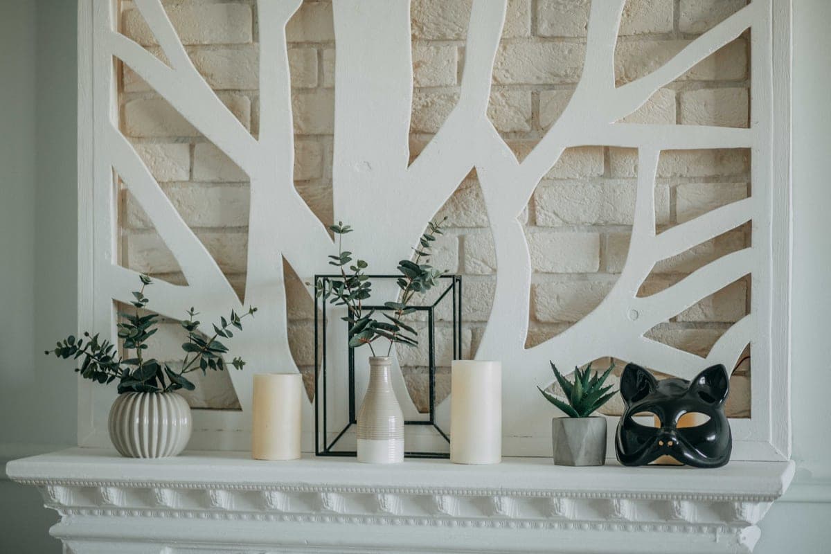 A wooden mantel shelf above a fireplace in a furnished room