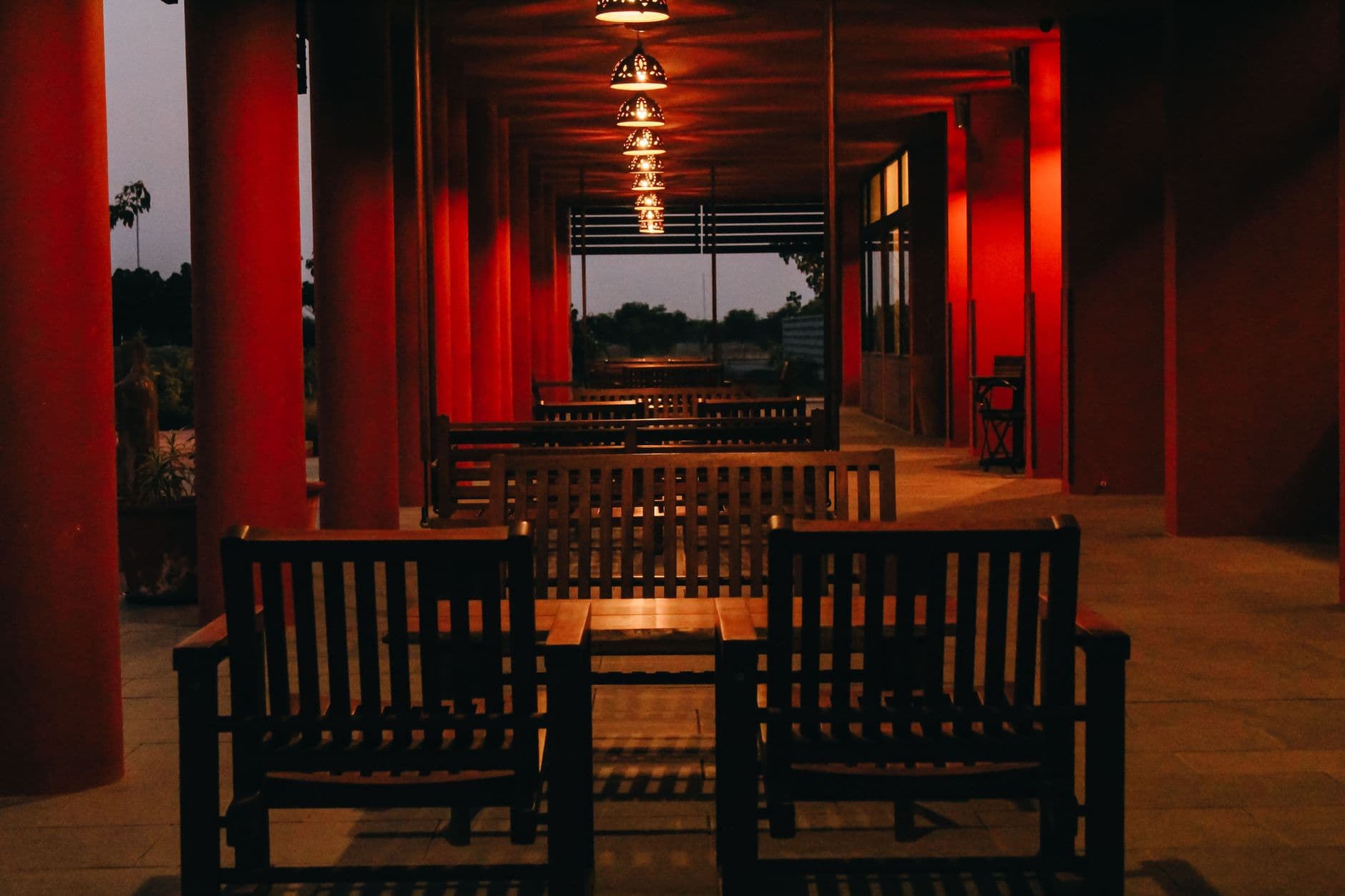 An outdoor wooden seating area warmly lit in the evening