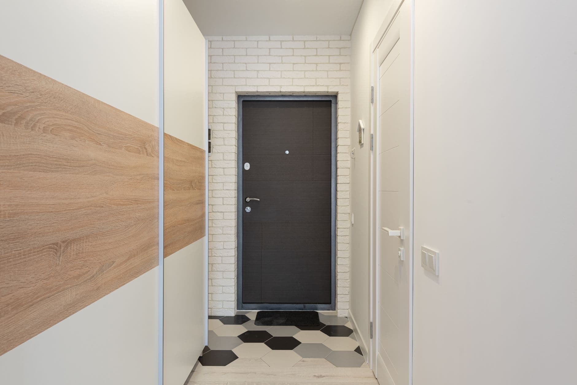 A narrow passage in a house with a white brick wall